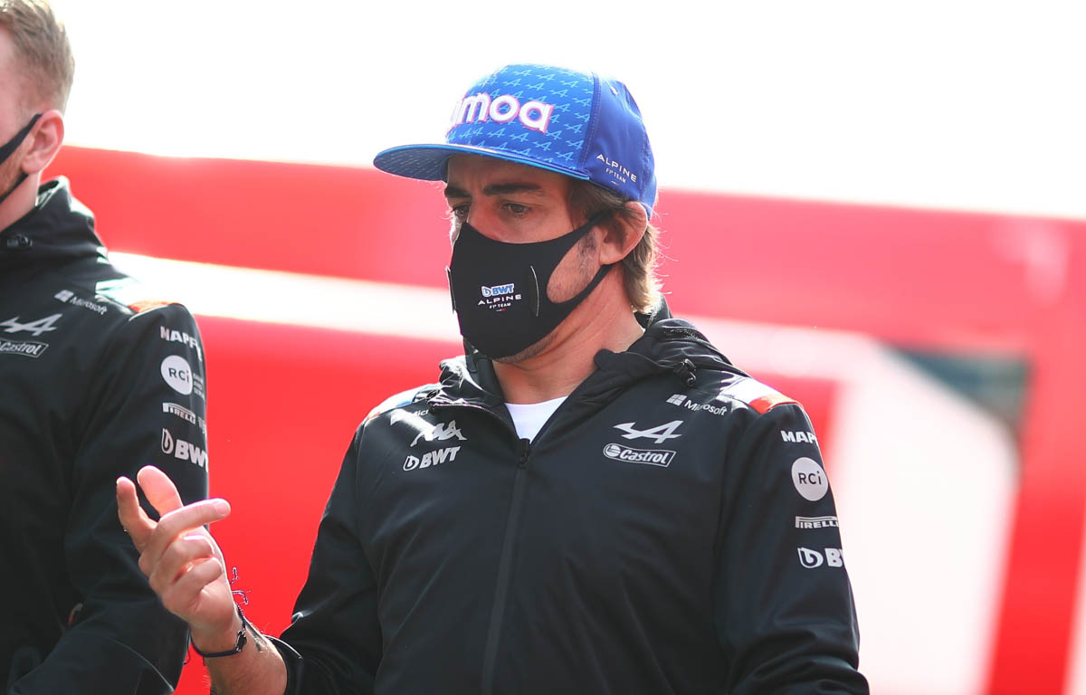 Fernando Alonso walks in a cap and mask. Barcelona February 2022.