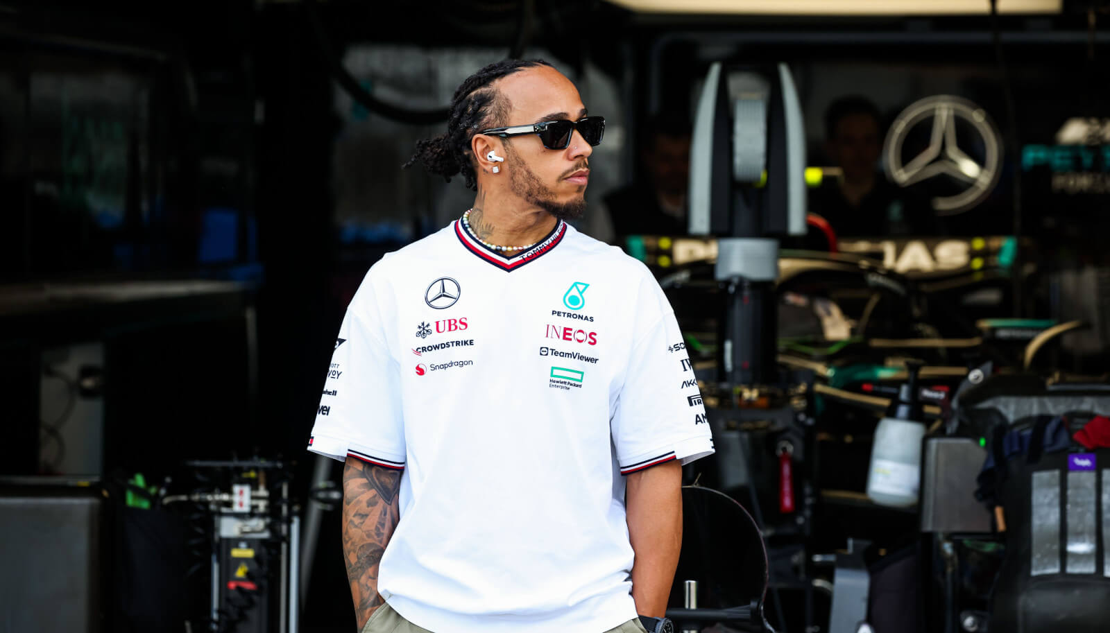 Lewis Hamilton standing in front of the Mercedes garage