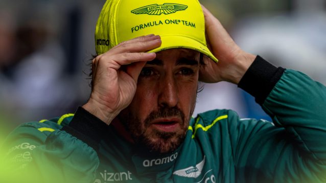 Fernando Alonso adjusts his cap