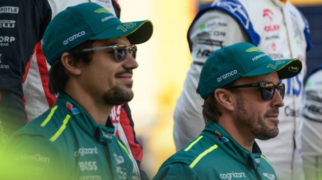Lance Stroll and Fernando Alonso stand side by side in a photoshoot involving the entire F1 2024 grid