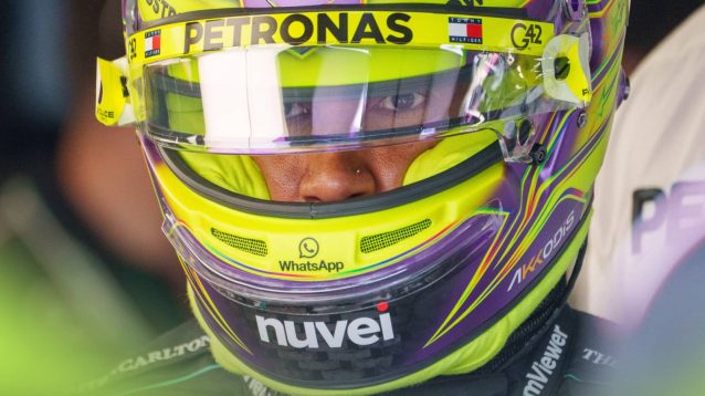 Lewis Hamilton's eyes are visible through the visor of his helmet in the Mercedes garage during Canada practice