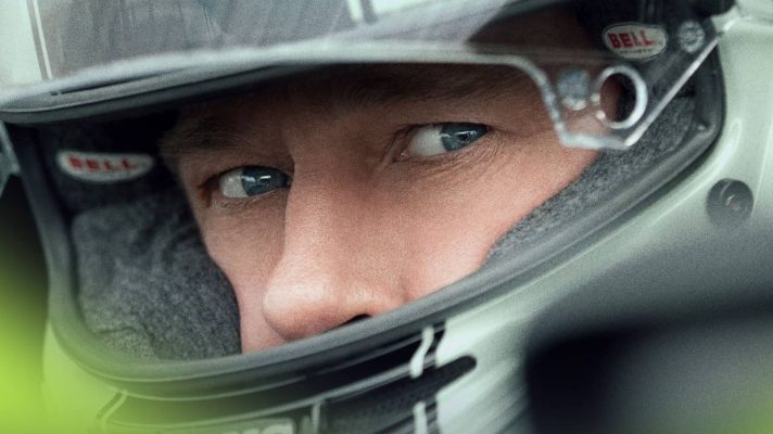 A close-up shot of Brad Pitt's eyes through the visor of a helmet in the F1 movie poster