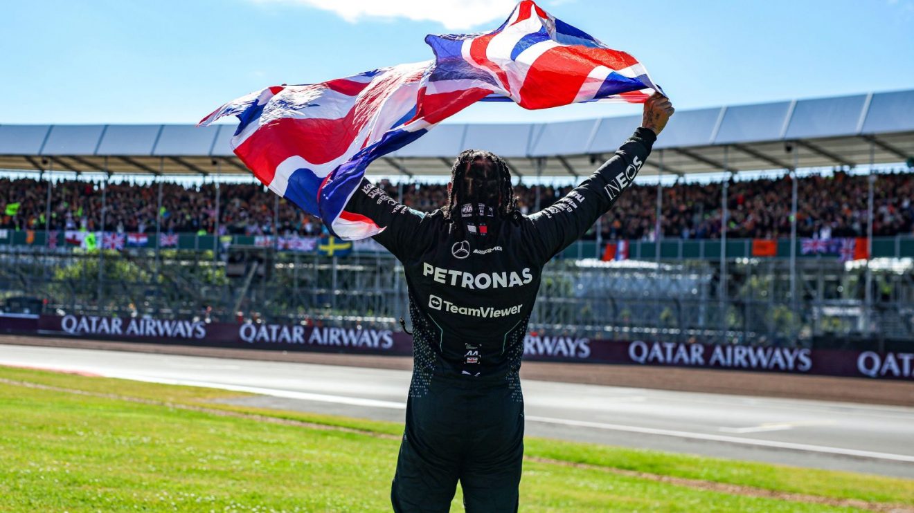 Lewis Hamilton holds up the British flag after winning the 2024 British Grand Prix.