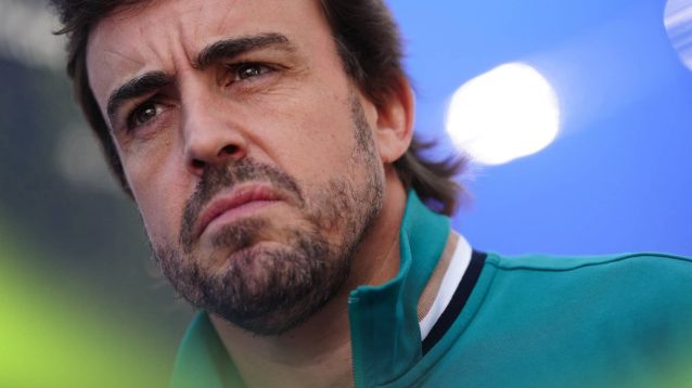 A close-up shot looking up at Fernando Alonso as he makes his way through the paddock at Imola