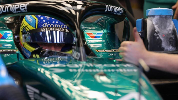 Fernando Alonso in his Aston Martin, mechanic giving a thumbs up
