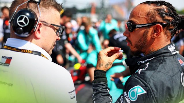 Pete Bonnington and Lewis Hamilton in conversation on the grid in Hungary as mechanics work on the Mercedes W15 in the background