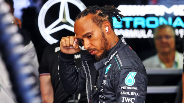 Lewis Hamilton in the Mercedes garage in front of the team's logo