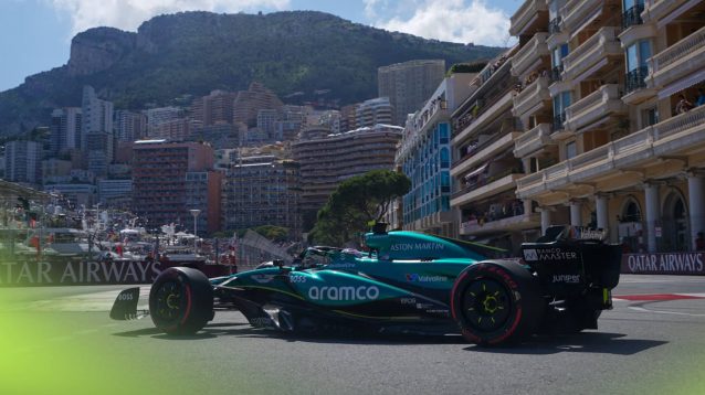Fernando Alonso enters the Nouvelle chicane with the stunning Monte Carlo backdrop towering over his Aston Martin