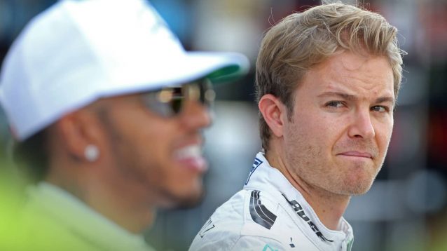 A tense Nico Rosberg glances over at a smiling Lewis Hamilton during a Mercedes team photoshoot in Abu Dhabi in 2016