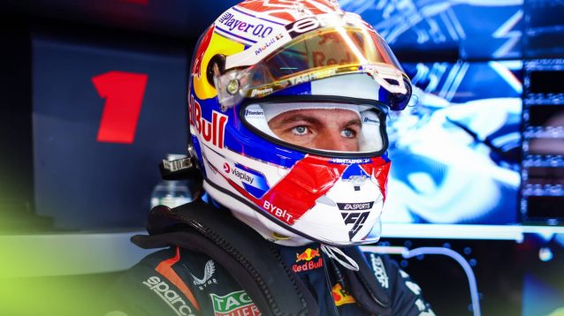 Max Verstappen has his visor open as he looks out from the back of the Red Bull garage at Monza