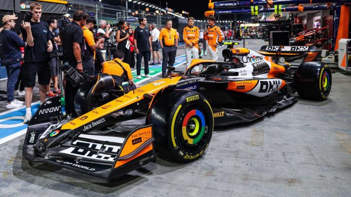 The McLaren MCL38 in its special 'Legend Reborn' livery at the 2024 Singapore Grand Prix, with Lando Norris, Oscar Piastri and Zak Brown standing by.