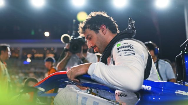 Daniel Ricciardo lowers his head as he climbs out of his cockpit on the starting grid in Singapore