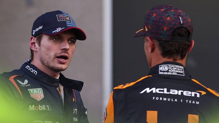 Max Verstappen in animated conversation with Lando Norris, who has his back turned