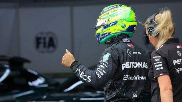 Lewis Hamilton with thumbs up in the pit lane.