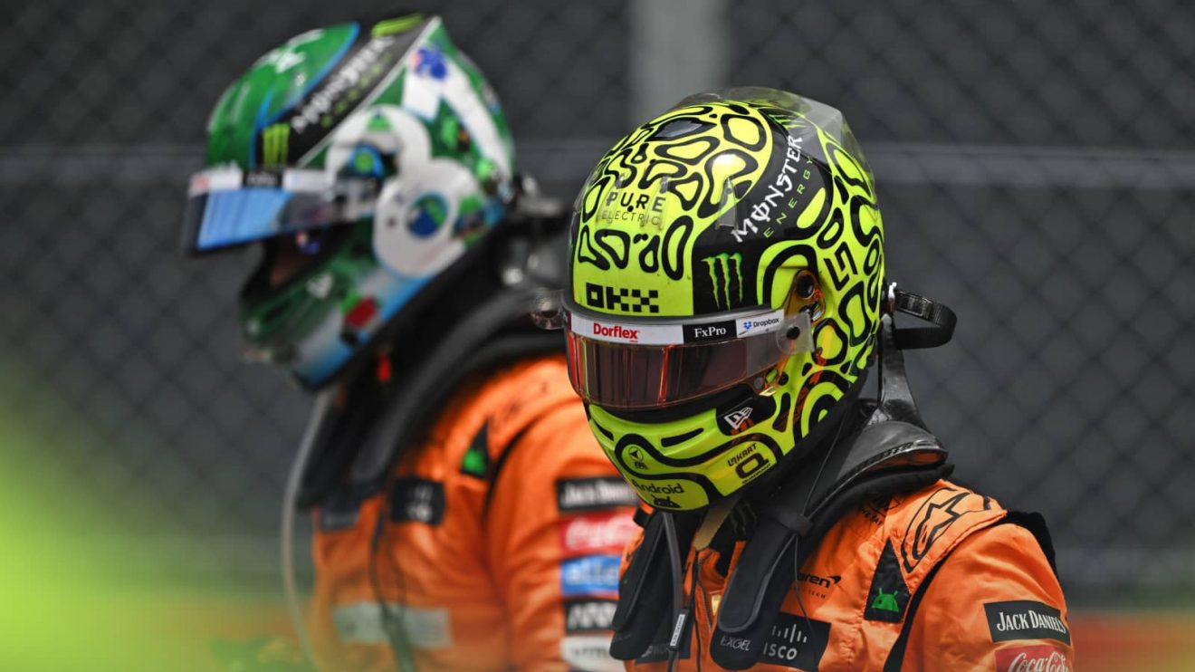 Lando Norris in full racing apparel on the grid at Interlagos with Oscar Piastri in the background
