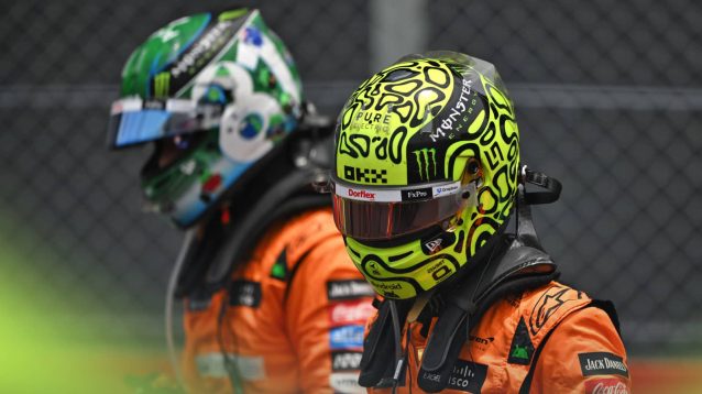 Lando Norris in full racing apparel on the grid at Interlagos with Oscar Piastri in the background