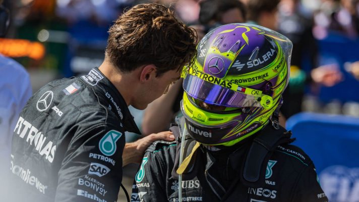 George Russell with a hand on Lewis Hamilton's shoulder