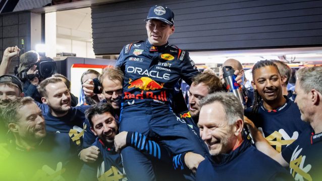 Max Verstappen is held aloft by members of the Red Bull team including Christian Horner