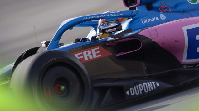 A zoomed-in shot of Fernando Alonso on track testing for Alpine in 2022