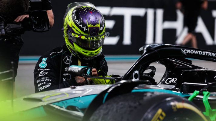 Lewis Hamilton kneels beside his Mercedes W15 on the grid after the Abu Dhabi GP