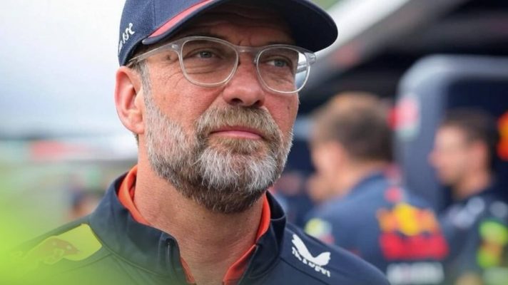 A mock-up image of Jurgen Klopp in Red Bull uniform with a group of mechanics stood behind him
