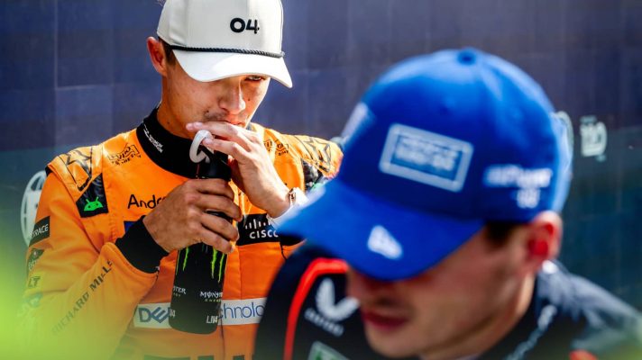 Lando Norris sips from a straw in parc ferme with Max Verstappen smiling in the foreground