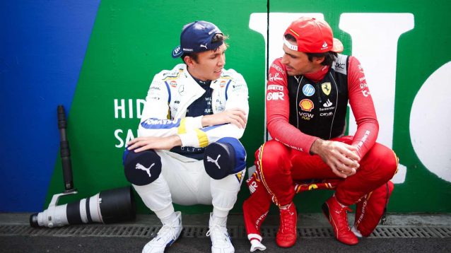 Alex Albon and Carlos Sainz crouch alongside one another.