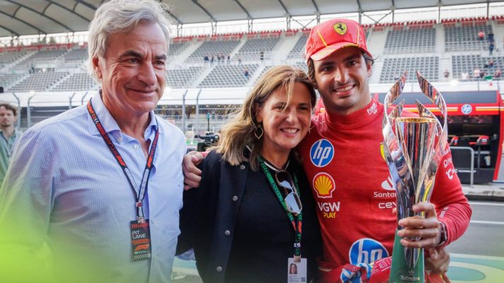 Carlos Sainz poses with his parents while holding the winners' trophy in Mexico in 2024