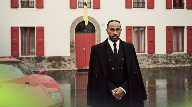 Lewis Hamilton posing outside of Enzo Ferrari's office at Maranello with a sepia-style tint