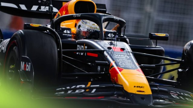 An action shot of Max Verstappen on track with the Red Bull RB20 at night in Abu Dhabi