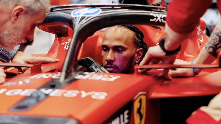 Lewis Hamilton sat in the cockpit of a Ferrari F1 car without his helmet on