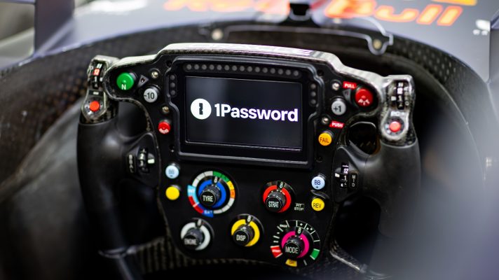 The Red Bull steering wheel with 1Password displayed on it.