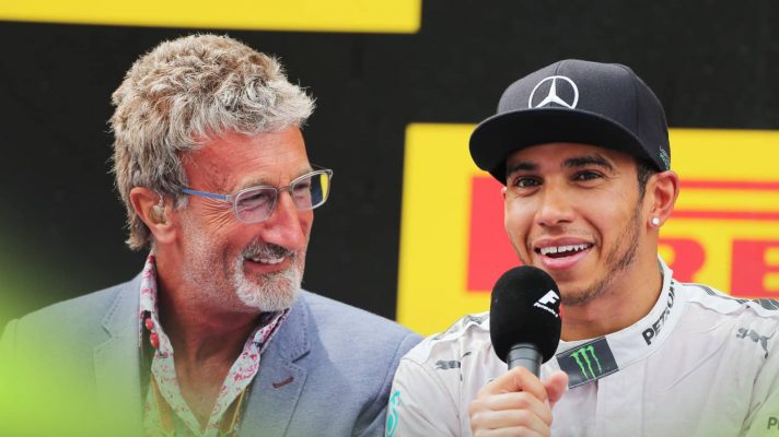 Eddie Jordan smiles as he interviews Lewis Hamilton on the podium