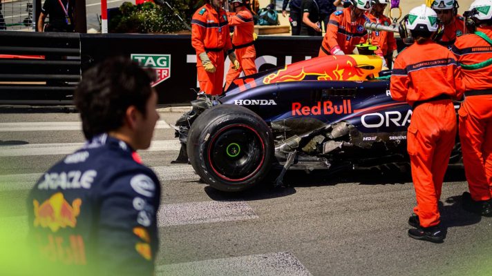 Sergio Perez looks on as his destroyed Red Bull RB20 is attended to by marshals in Monaco