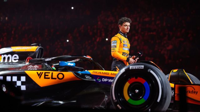 Lando Norris stands next to the McLaren at the F1 75 event