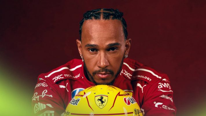 A studio shot of Lewis Hamilton resting his head on his yellow Ferrari helmet