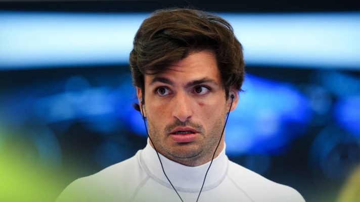 Carlos Sainz looks on in the garage