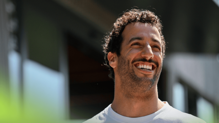 Daniel Ricciardo smiles broadly in the F1 paddock
