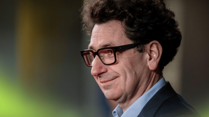 A side-profile shot of Audi F1 boss Mattia Binotto smiling