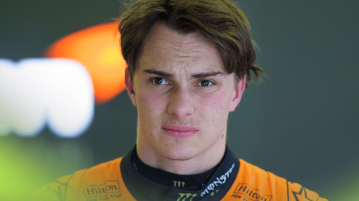 Oscar Piastri wearing McLaren overalls in the garage