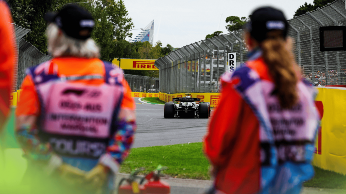 A rear-facing shot of Nico Hulkenberg exiting Turn 2 in Australia with his car framed between two marshals