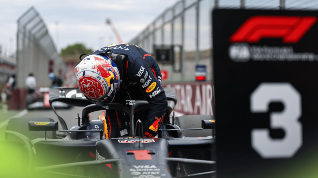 Max Verstappen refits his steering wheel as he climbs out of his Red Bull in front of the P3 board in parc ferme