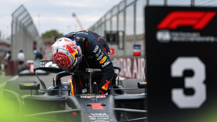 Max Verstappen refits his steering wheel as he climbs out of his Red Bull in front of the P3 board in parc ferme