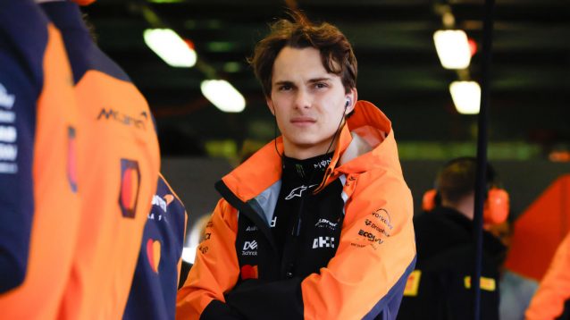 Oscar Piastri with his arms crossed in the McLaren garage