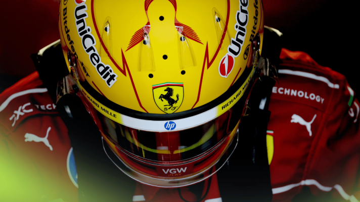Lewis Hamilton lowers his head to reveal the top surface of his yellow Ferrari helmet