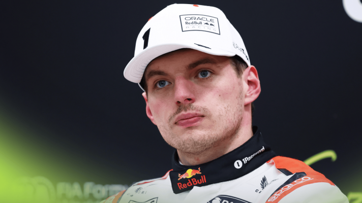 Max Verstappen looks on in a press conference while wearing Red Bull's special white uniform for the 2025 Japanese GP