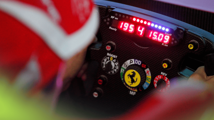 A close-up shot of an old Ferrari F1 steering wheel with fourth gear engaged