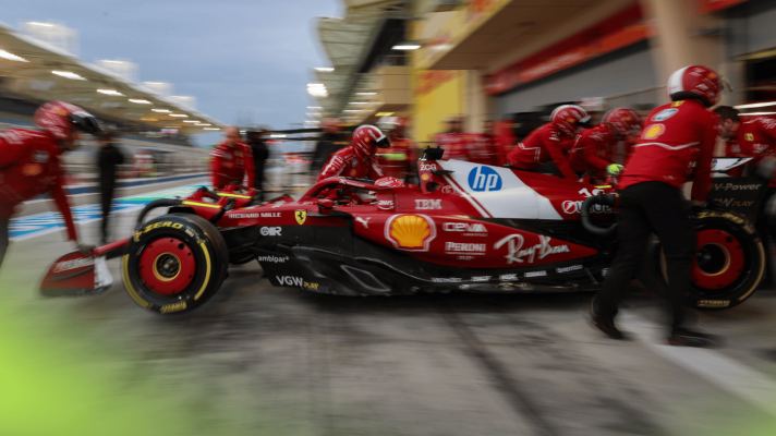A group of Ferrari mechanics wheel Charles Leclerc's car back into the garage in Bahrain