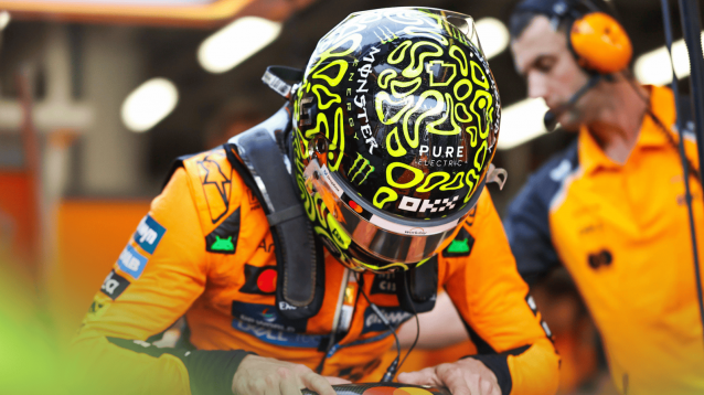 Lando Norris lowering himself into the cockpit in the McLaren garage