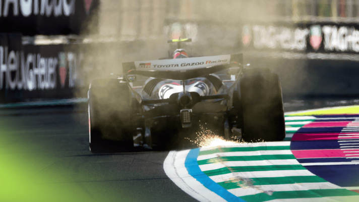 A rear-facing shot of Oliver Bearman's Haas running over the kerbs and kicking up sparks in Jeddah